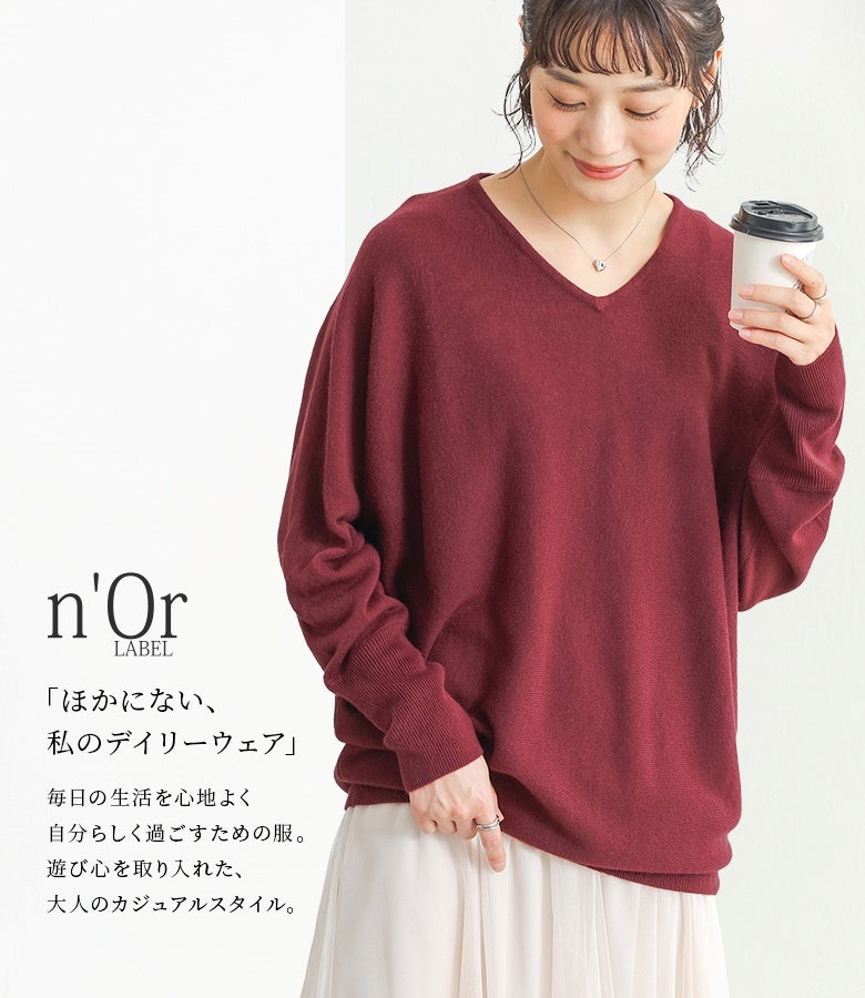 華やかで深みのあるワインカラーのVネックドルマンニット。柔らかなニット地とルーズなサイズ感が、フェミニンな白スカートとのスタイリングを大人可愛く演出します。