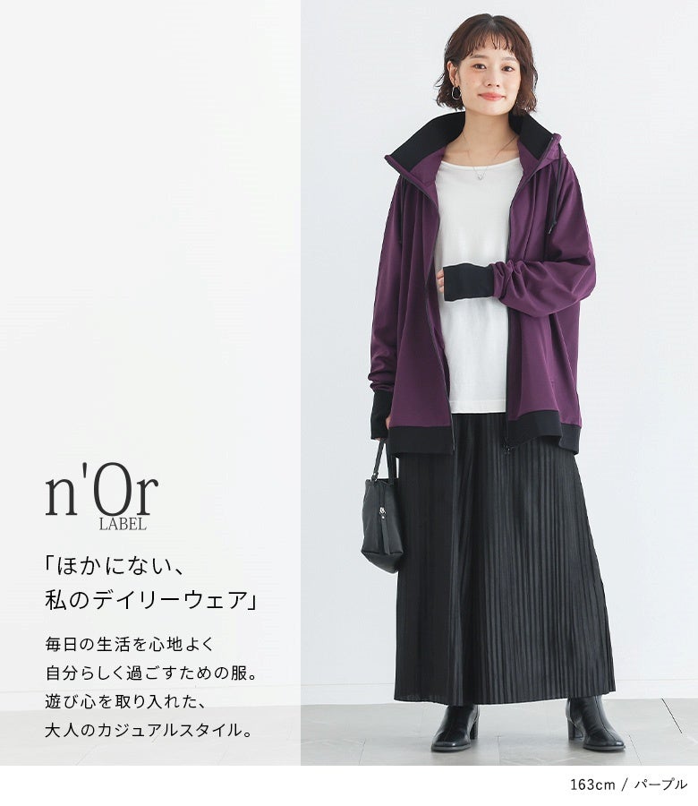 パープルのボリュームネックパーカーに白トップスと黒のプリーツスカートを合わせた大人カジュアルコーデ。秋のお散歩やカフェ巡りにも映える落ち着いたカラーリングです。