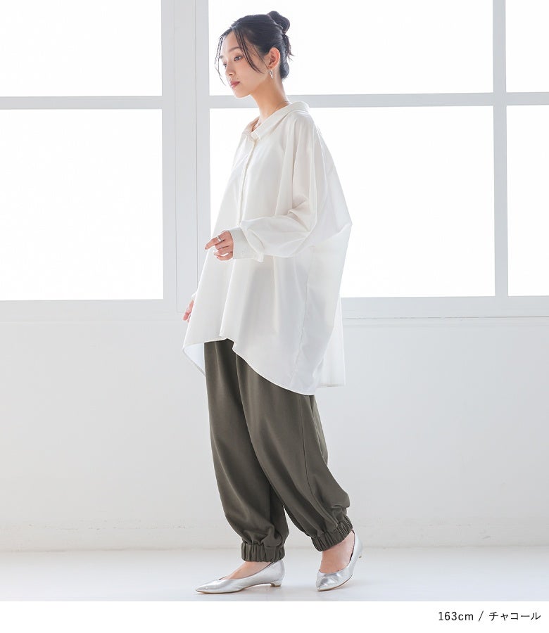 チャコールのサルエルパンツに白シャツとシルバーパンプスを合わせた好印象な装い。ゆったりとしたレッグラインとすっきりとした裾ゴムのメリハリが、洗練された横姿を叶えます。