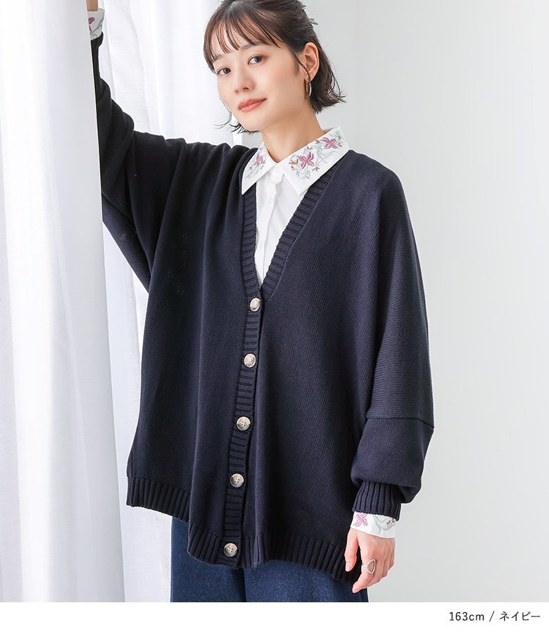 シックなネイビーのVネックニットカーディガンと刺繍襟シャツの重ね着スタイル。オフィスやきれいめカジュアルにも馴染む知的な着こなしです。