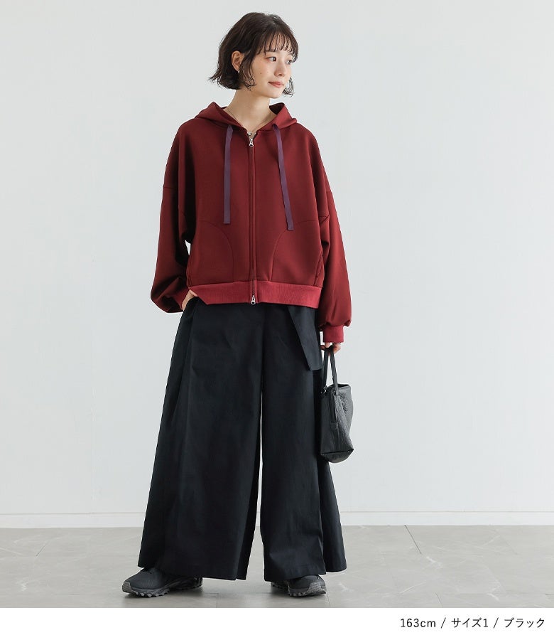 ブラックのベルトカシュクールワイドパンツにボルドーのジップパーカーを合わせた大人カジュアル。ラップデザインと贅沢な生地感が、ラフなパーカーコーデを洗練されたモードな装いへ昇華させます。