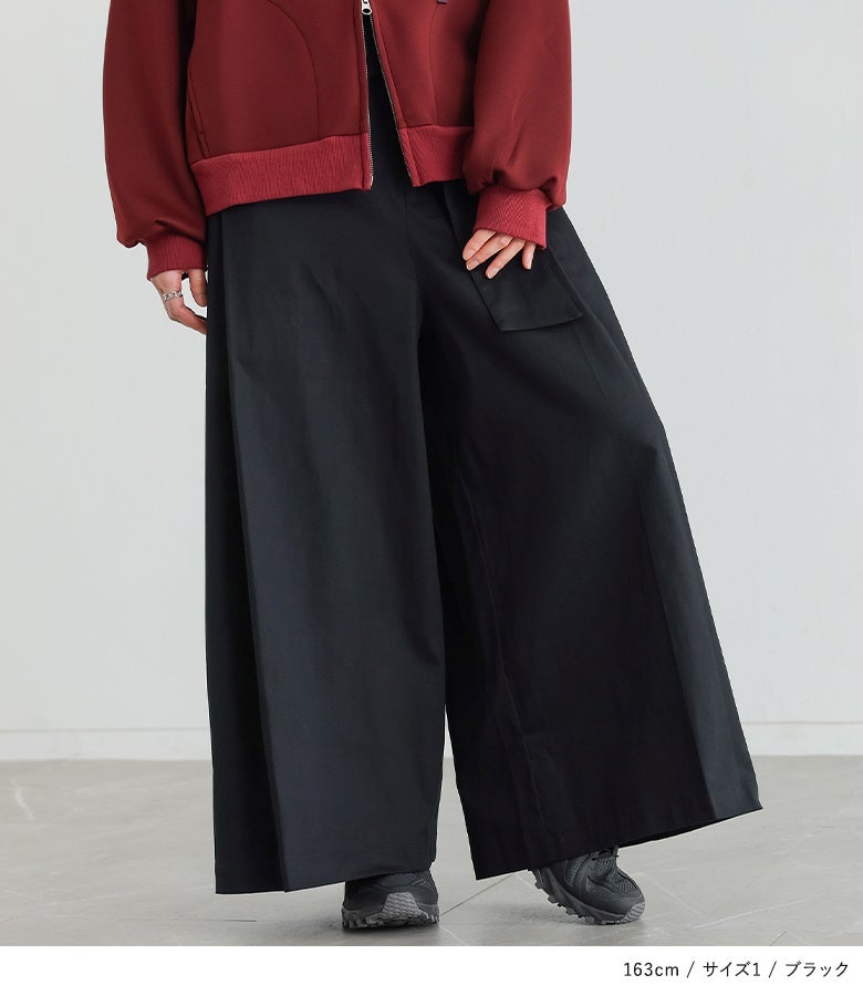 ブラックのベルトカシュクールワイドパンツ。重厚感のあるシックな黒とゆったり広がるカシュクールラインが相まって、脚長効果を発揮しながら足元までスタイリッシュに引き締めます。