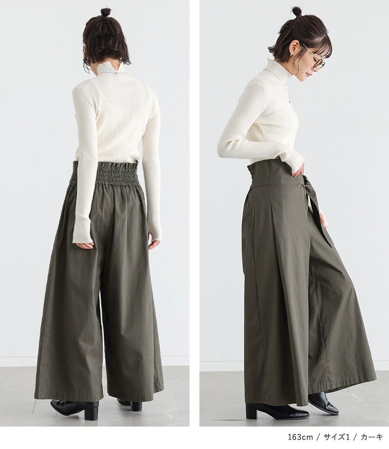 カーキのベルトカシュクールワイドパンツ。ウエスト後ろ部分に施されたシャーリングゴム仕様が背中に心地よくフィットし、全方位どこから見ても抜かりなくきれいなシルエットをキープします。