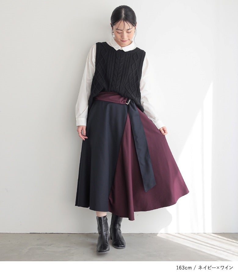 ネイビー×ワインの配色フレアスカートに黒ニットベストと白シャツをあわせたきれいめスタイル。裾に向かって優美に広がる配色ドレープが、大人のこなれ感を品良く演出します。