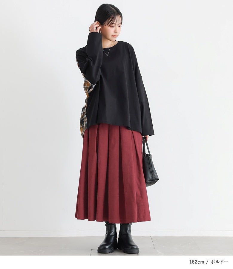 ボルドーのスエードタッチタックスカートに黒カットソーを合わせたスタイル。美しく広がるフレアラインと深みのあるボルドーが、スタイリング全体を華やかでスマートに惹き立てます。