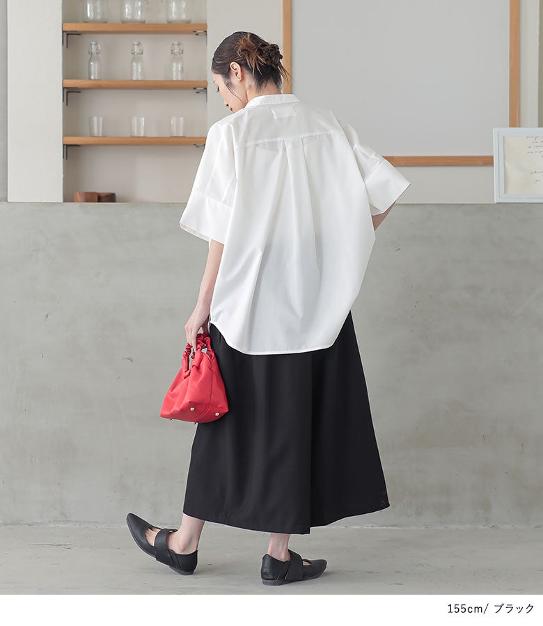 ブラックの大人ガウチョパンツとオーバーサイズの半袖白シャツを合わせた、風通しの良い夏のお出かけリラックスコーディネート。