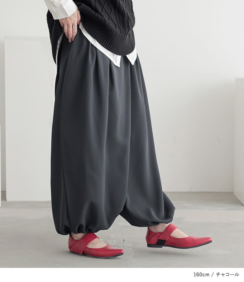 チャコールのアラビアンワイドパンツ。深めのタックが作り出す流れるようなドレープラインが、立ち姿や歩く動作に動きのある洗練されたニュアンスをプラスします。