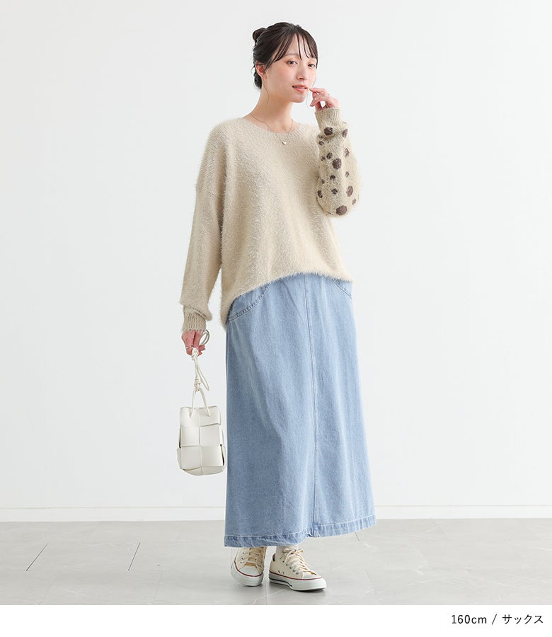 サックスのデニムスカートに袖柄シャギーニットとミニバッグを合わせた、優しげな雰囲気が漂う休日のショッピング向けフェミニンコーディネート。