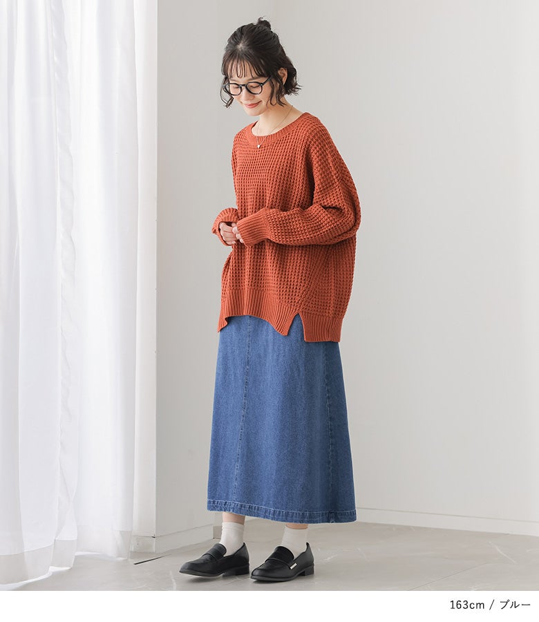 ゆったりとしたテラコッタニットとブルーのロングデニムスカートの組み合わせ。縦ラインが強調され、体型カバーとスタイルアップを両立します。