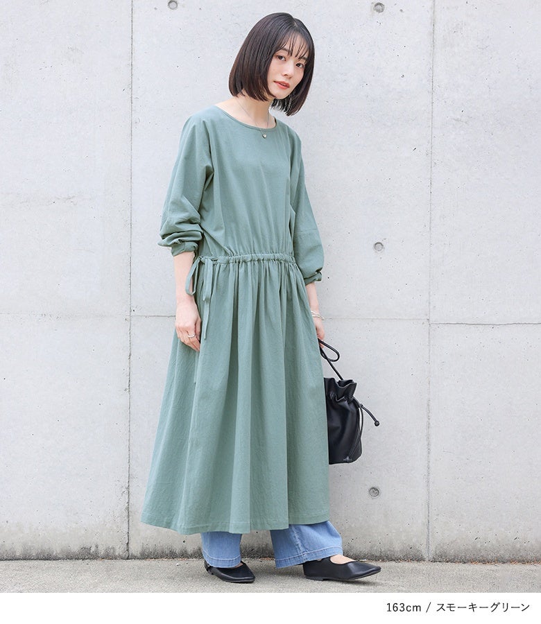 スモーキーグリーンの風合いコットンロングワンピースにワイドデニムパンツをあわせた大人カジュアル。ウエストのギャザーディテールが、パンツ重ねでももたつかず綺麗に決まります。