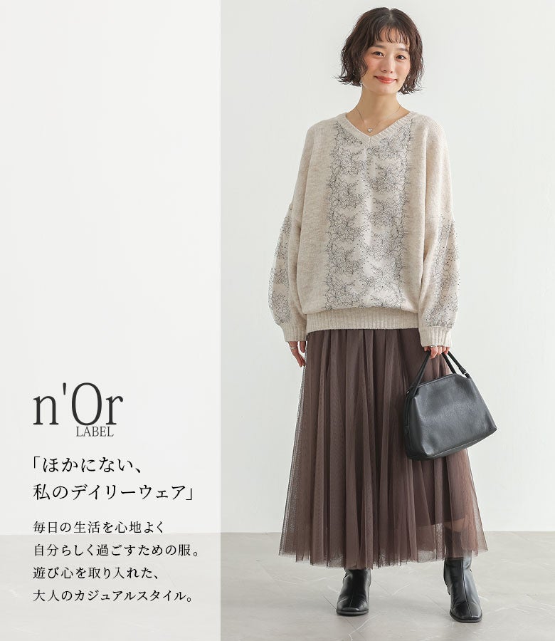 エクリュの配色レースニット。柔らかくまろやかなトーンと優美な透かしレースが、ブラウンのチュールスカートをあわせたフェミニンスタイルを上品に彩ります。