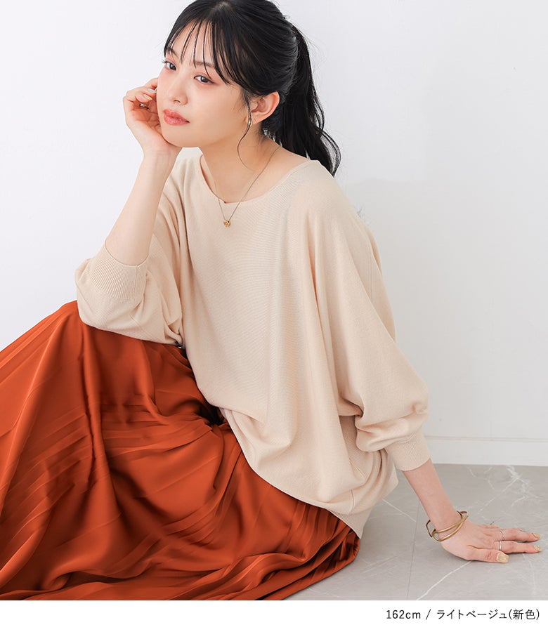 新色ライトベージュの7分袖ドルマンニットにテラコッタのプリーツスカートを合わせた、春先や秋口のカフェ巡りやデートに最適な華やか大人カジュアルコーデ。