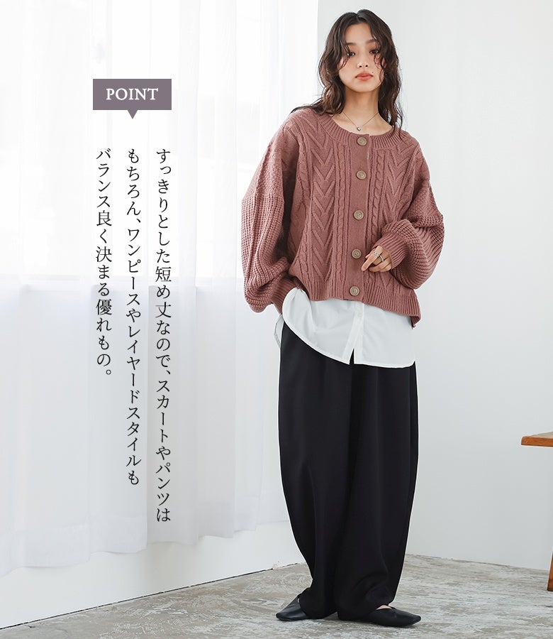 グレイッシュピンクの短め丈ニットカーディガンに白シャツと黒のワイドパンツを重ねた、バランスの良い大人のレイヤードスタイル。