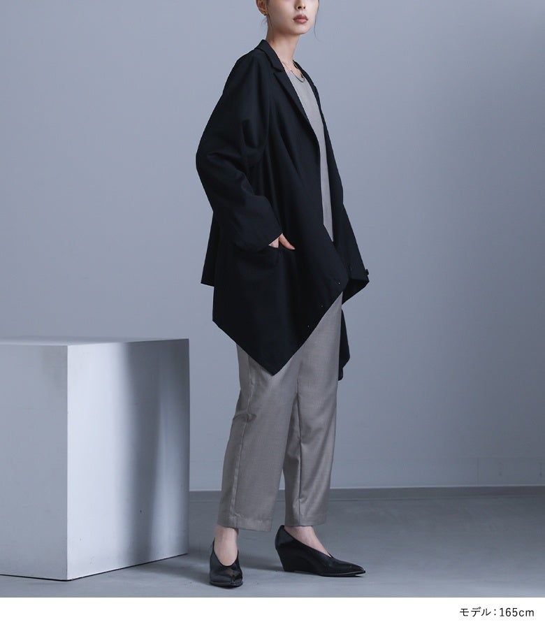 ブラックのボタン変形デザインジャケット。腰周りを自然にカバーするミドル丈とサイドポケット仕様が、デザイン性だけでなく日常使いの機能性も提供します。