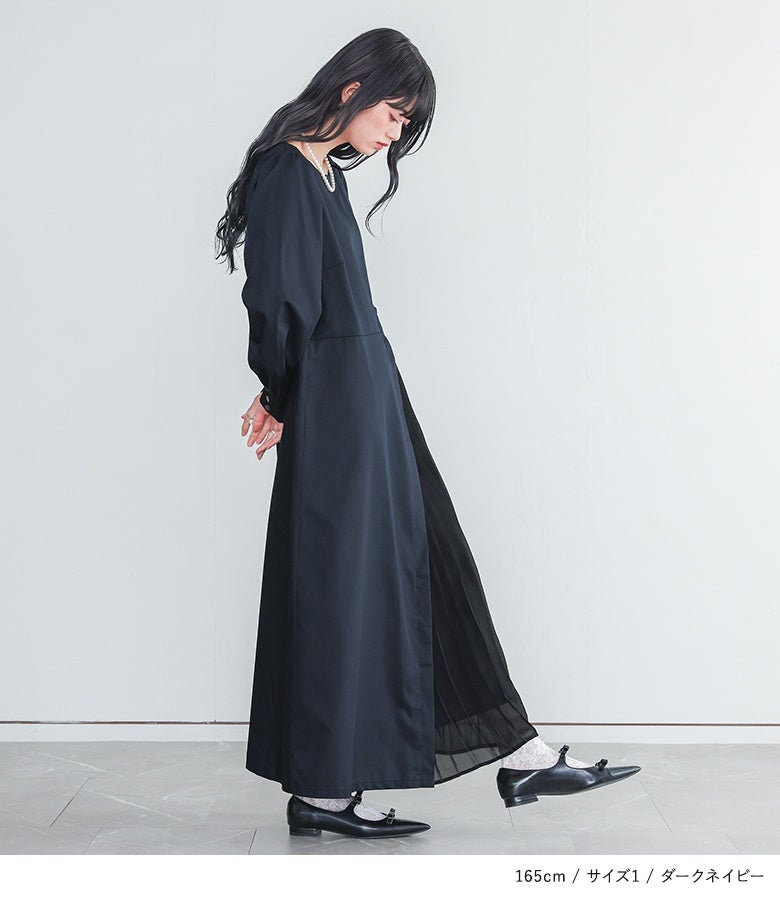 ダークネイビーのサイドプリーツロングワンピース。サイドから広がるシフォンプリーツの繊細な透け感と綺麗なAラインが、横姿も軽やかでエレガントに印象付けます。