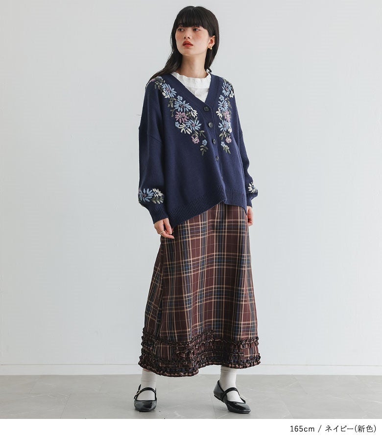 新色ネイビーの手刺繍Vネックニットカーディガン。深みのあるネイビー地にクラシカルな花刺繍が華やかに映え、チェック柄スカートと合わせた上品なレトロスタイルを叶えます。
