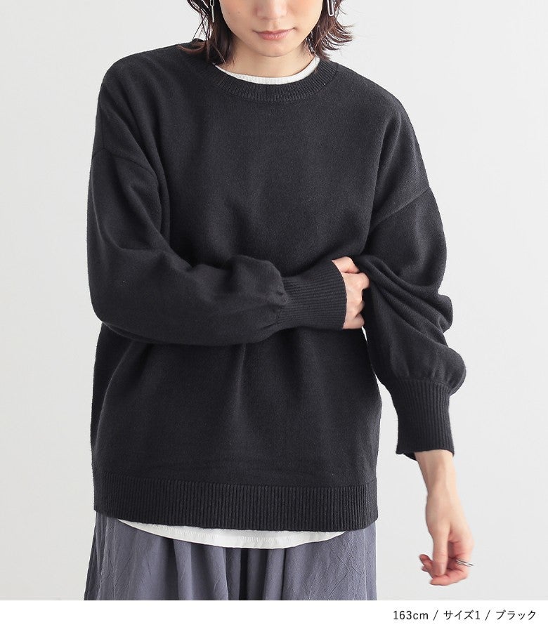 ブラックのぽわん袖パフスリーブニット。シックな黒の万能さとインナーカットソーを覗かせる裾レイヤードが、シンプルながら洗練された大人のラフスタイルを惹き立てます。