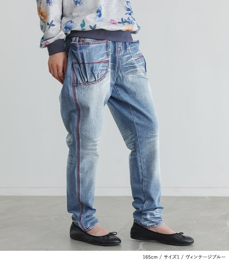 ヴィンテージブルーの赤ステッチ赤ジップサルエルデニムパンツ。サイドを走る赤ステッチラインが脚長効果を発揮し、ゆったりとした履き心地ながらすっきり見せを叶えます。