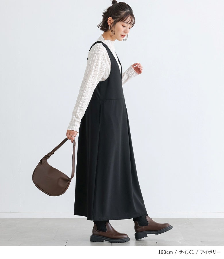アイボリーのウェーブハイネックカットソーに黒のジャンパースカートを合わせたスタイル。サイドから見ても美しいひし形風模様とメロー使いが、スッキリとした縦ラインを引き立てます。