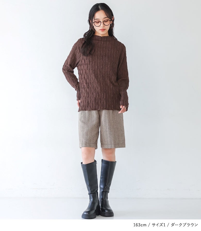 ダークブラウンのウェーブハイネックカットソーにショートパンツをあわせたスタイル。深みのあるブラウンカラーと手元のメローデザインが、大人シックな雰囲気を演出します。