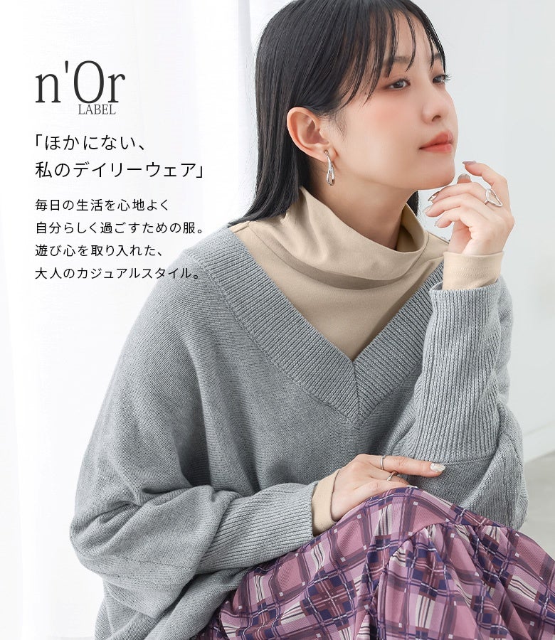 ベージュのタートルネックロンT。Vネックニットのインナーとして合わせることで、首元に優しいアクセントを添え暖かみのある重ね着スタイルを完成させます。