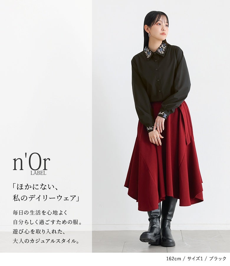 ブラックの花刺繍シャツにボルドーのイレギュラーヘムスカートを合わせた大人の着こなし。顔周りと袖口の繊細な刺繍使いが際立ち、洗練された大人のデイリースタイルを完成させます。