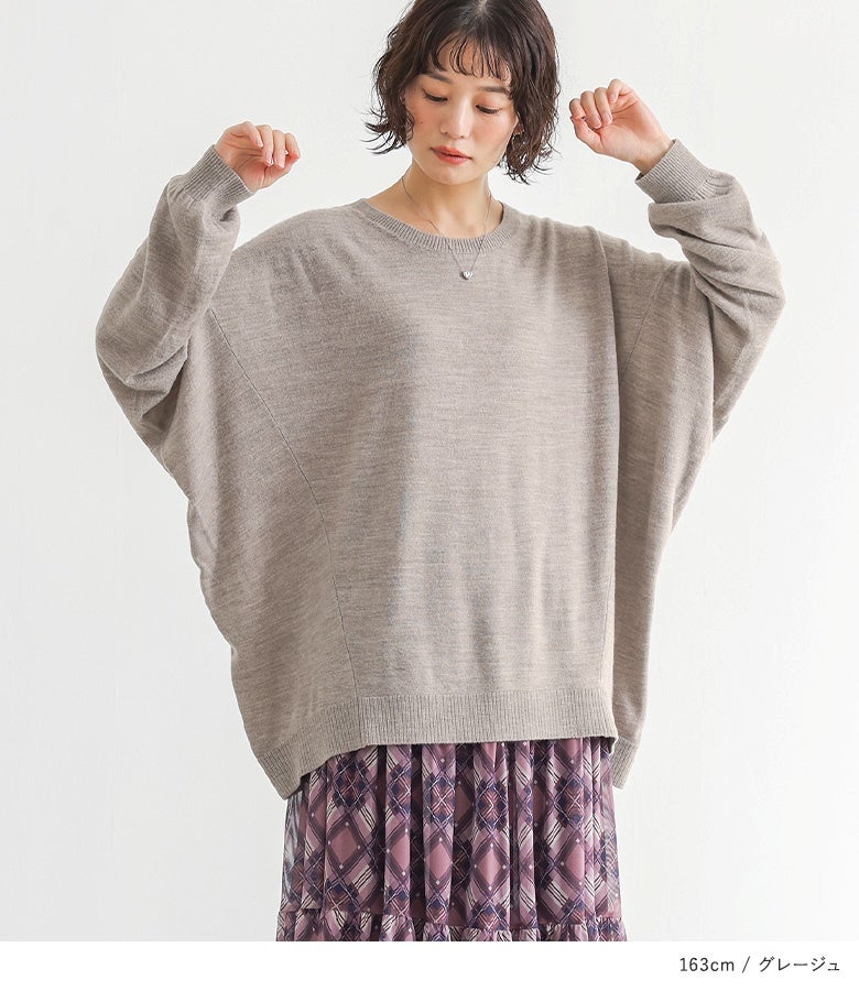 グレージュのカシミヤタッチ変形ドルマンニットに紫のチェック柄フレアスカートをあわせた、やわらかく上品なフェミニンテイストのデートスタイル。