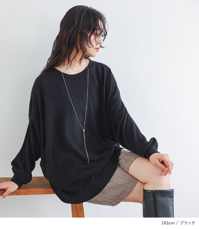 ブラックの変形ドルマンニットにヘリンボーン柄ショートパンツ、ロングブーツをあわせた、Y字ネックレスが映える洗練された大人の休日ショッピングコーデ。