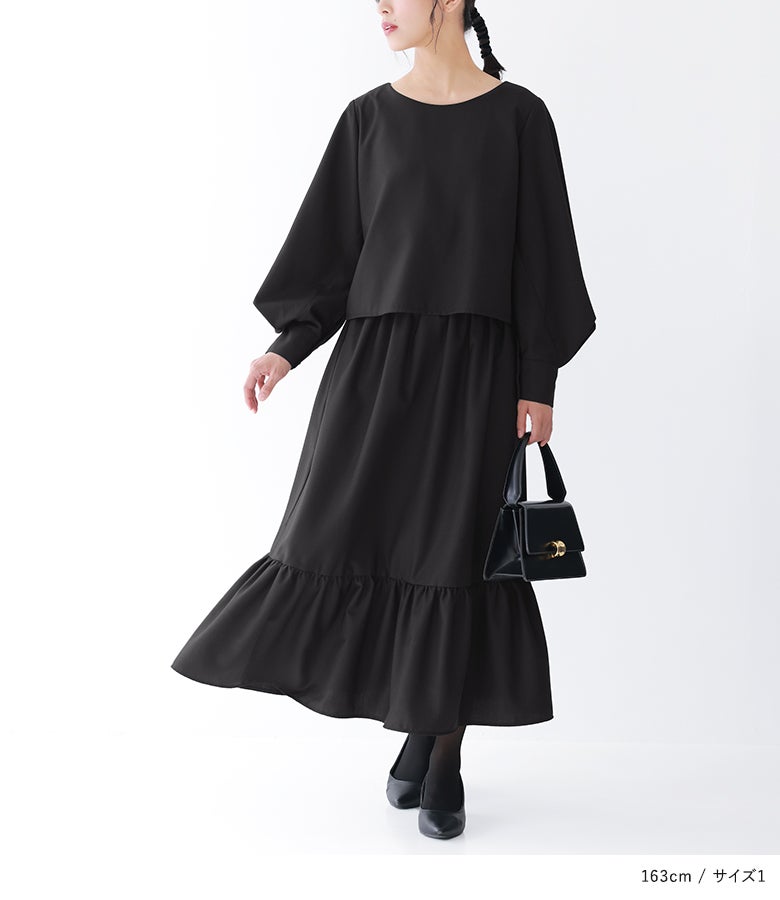 ブラックのティアードドレスに黒のレザーバッグとパンプスを合わせたシックな結婚式お呼ばれコーデ。上品なワントーンスタイルで、パーティーからフォーマルな席まで活躍します。