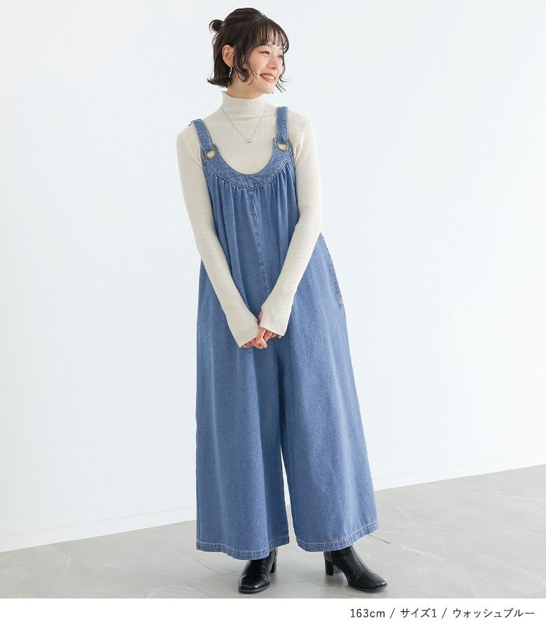 ウォッシュブルーのデニムサロペットに白のハイネックリブニットを合わせた、ナチュラルなこなれ感が漂う大人のかわいい休日お出かけコーデ。