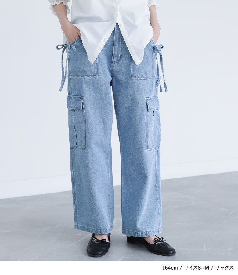 サックスのサイドリボンカーゴデニムパンツ。両腰から流れるデニムリボンと立体的なポケットワークが正面からの存在感を高め、シンプルな白シャツを合わせるだけでお洒落に決まります。