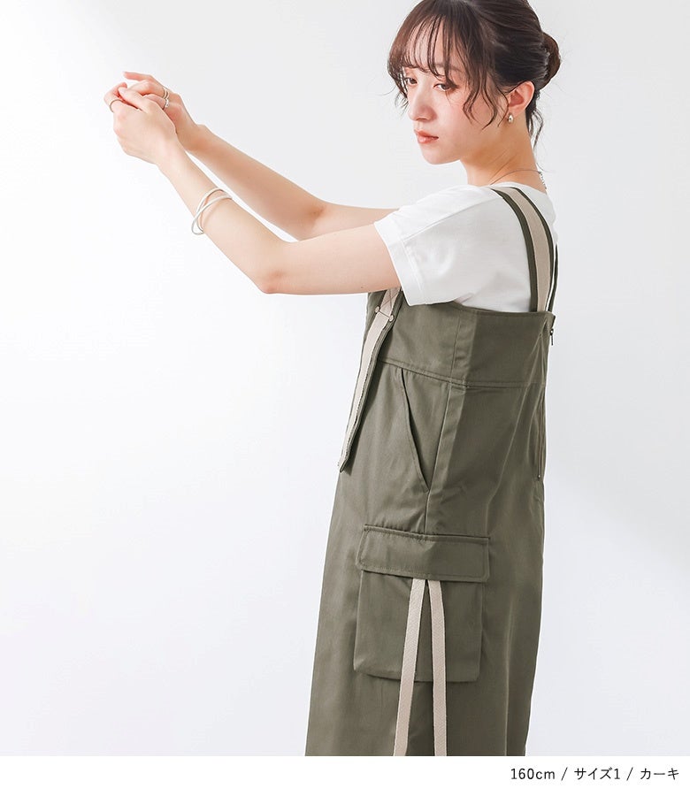 深めの胸元スリットと配色ストラップが顔周りをすっきり見せるカーキのサロペットスカート。サイドのカーゴポケットがアクセントになり、シンプルなインナーとも相性抜群です。