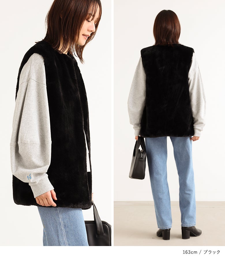 黒のフェイクファージレにグレーの長袖スウェットとライトブルーのデニムパンツ、黒のレザーバッグを合わせた大人の着映えコーディネート。すっきりとしたノーカラーデザインで、トレンド感のあるこなれたスタイルに。