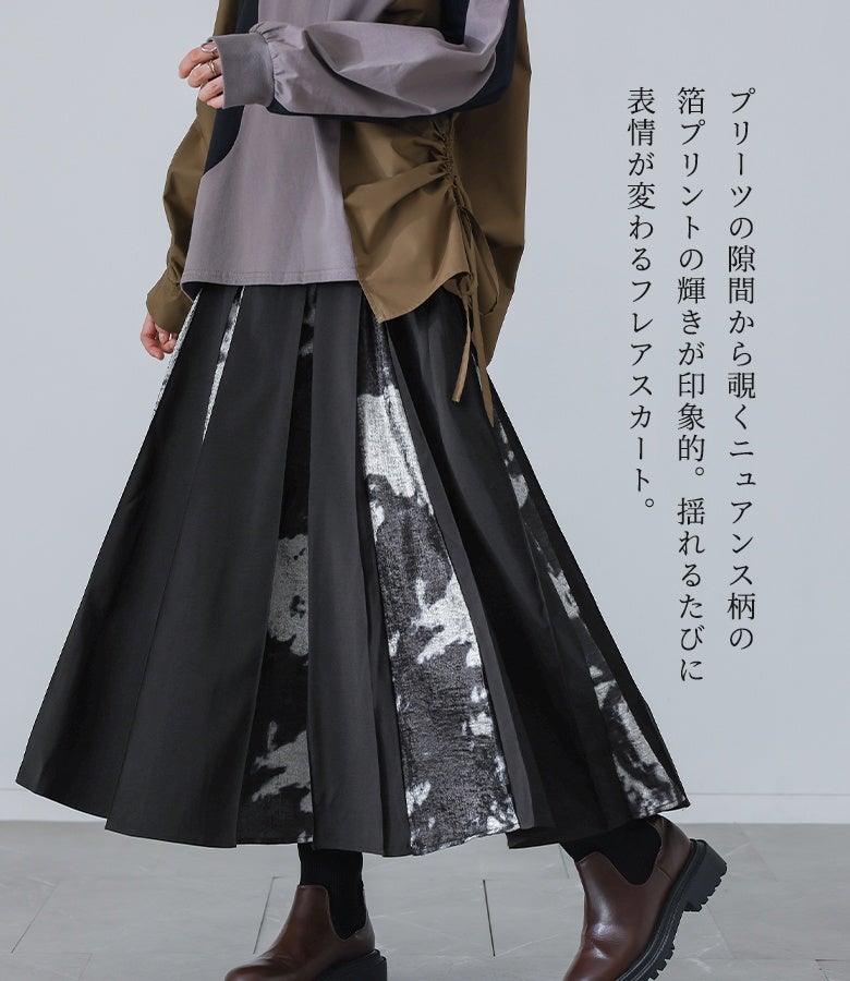 プリーツの隙間から覗くニュアンス柄の箔プリントの輝きが印象的。揺れるたびに表情が変わるフレアスカートで、いつもの着こなしをワンランク上のモードスタイルへ引き立てます。
