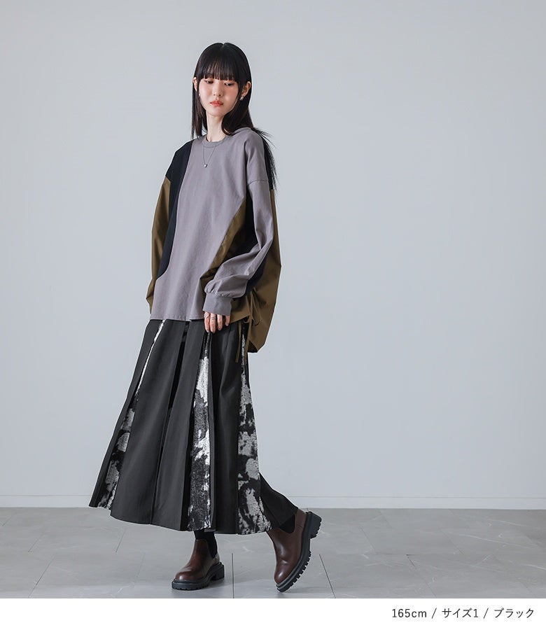 ブラックの箔プリント切替フレアスカート。広めのタックから覗く箔柄の立体感が印象的で、変形トップスとあわせても重たく見せない絶妙な抜け感をもたらします。