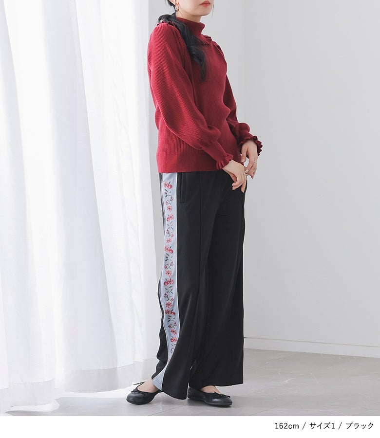 花柄刺繍のサイドラインがシックなアクセントになるブラックのラインパンツ。赤ニットと合わせたメリハリのある大人可愛いカジュアルスタイルに仕上がります。