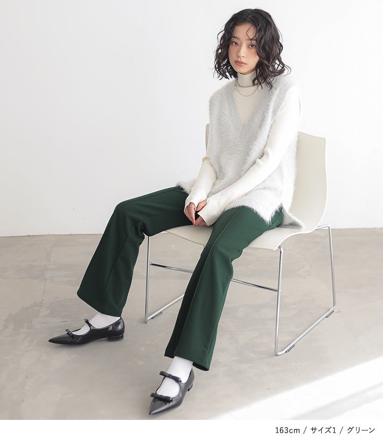 グリーンの裏起毛フレアパンツ。白のタートルネックにフェザーヤーンベストをレイヤードした装いに、深みのあるグリーンがクラシカルなアクセントを添えます。
