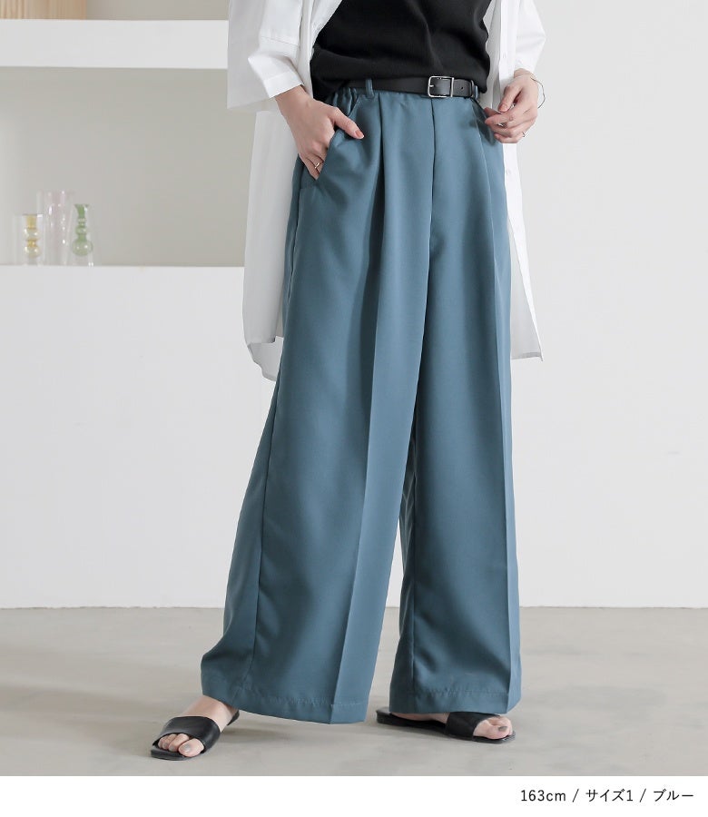 ブルーのセンタープレスタックワイドパンツ。深めのフロントタックとウェーブポケットが腰周りをスッキリとカバーし、落ち感のあるツイル生地が流れるような美ラインを描き出します。