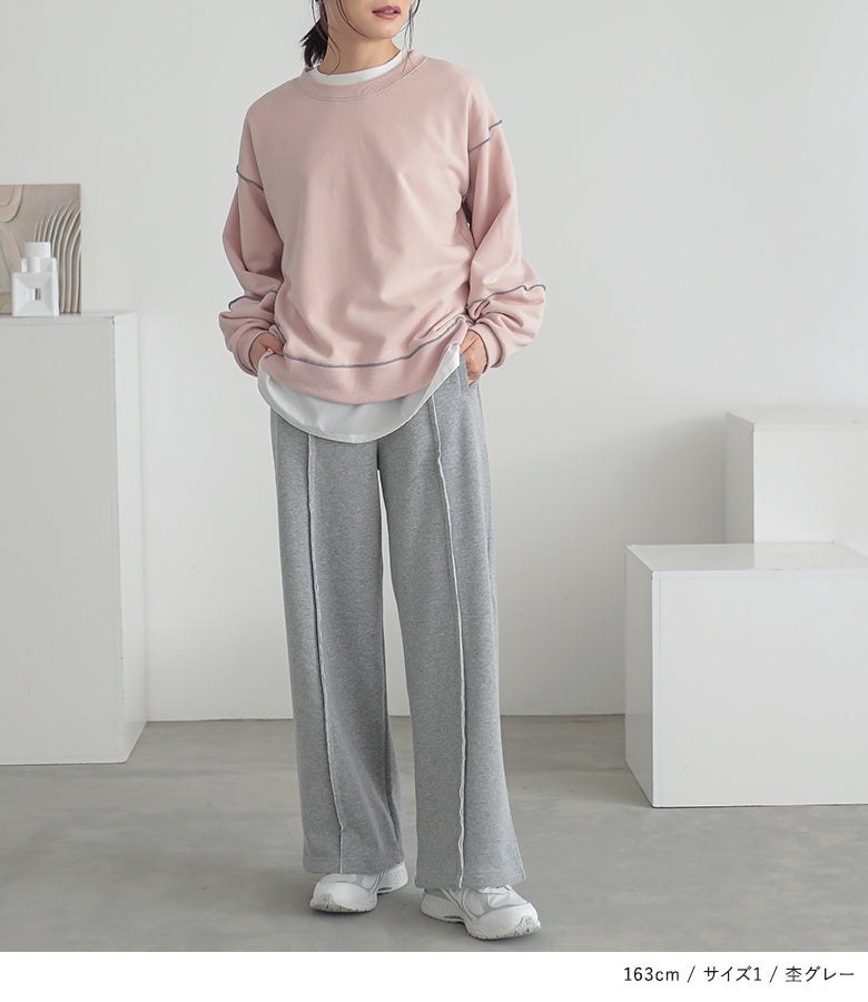 杢グレーのストレートワイドスウェットパンツにピンクのスウェットを合わせたカジュアルスタイル。フロントのセンター切り替えがラフな着こなしを美しく引き締め、脚長な印象へ導きます。