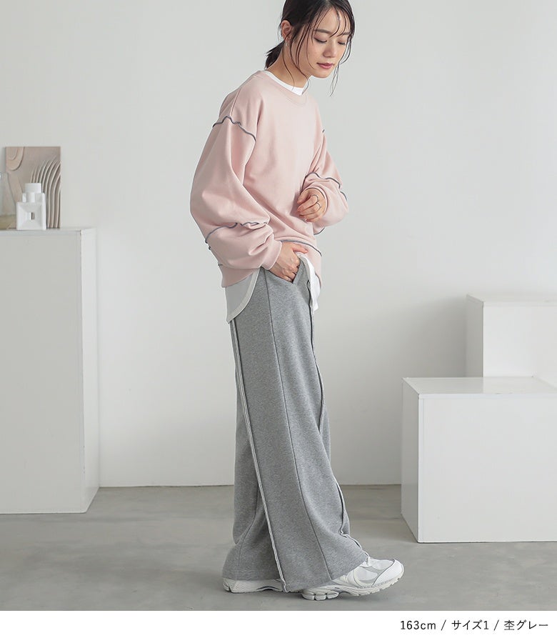 杢グレーのストレートワイドスウェットパンツ。落ち感のある柔らかな裏毛生地とセンターラインが、サイドから見た立ち姿までスッキリと縦長ラインに魅せてくれます。
