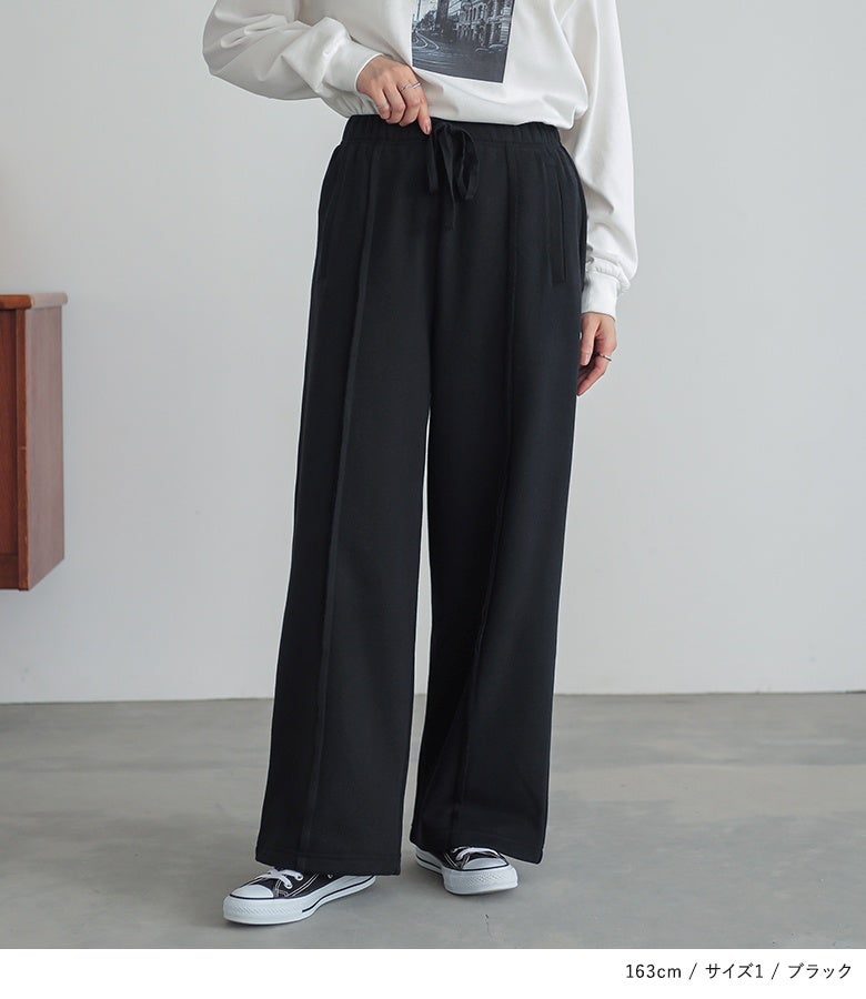 ブラックのストレートワイドスウェットパンツにプリントTシャツをあわせた着こなし。引き締め効果のある黒とセンター切り替えのラインが、スウェットでも品良くスマートな印象を与えます。