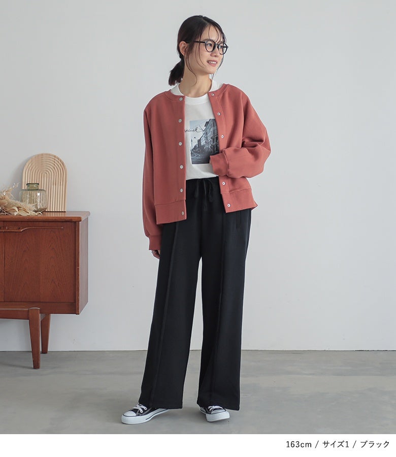 ブラックのストレートワイドスウェットパンツにピンクのカーディガンを羽織った旬コーデ。縦ラインを強調するセンター縫い代デザインが、スウェット特有の部屋着感を払拭しこなれた印象を与えます。