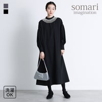 つけ襟デザインのパールネックレスが首元を華やかに彩るフレアワンピース。上品なフレアシルエットと袖口のパールボタンが大人っぽく、1着でオケージョンからお出かけまで上品に決まります。