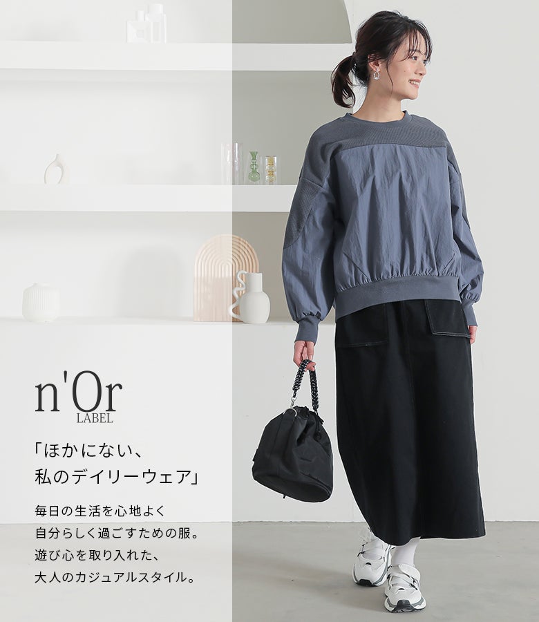 ブルーの異素材プルオーバーに黒のタイトロングスカートと白スニーカーをあわせた、アクティブな休日のお出かけカジュアルスタイリング。