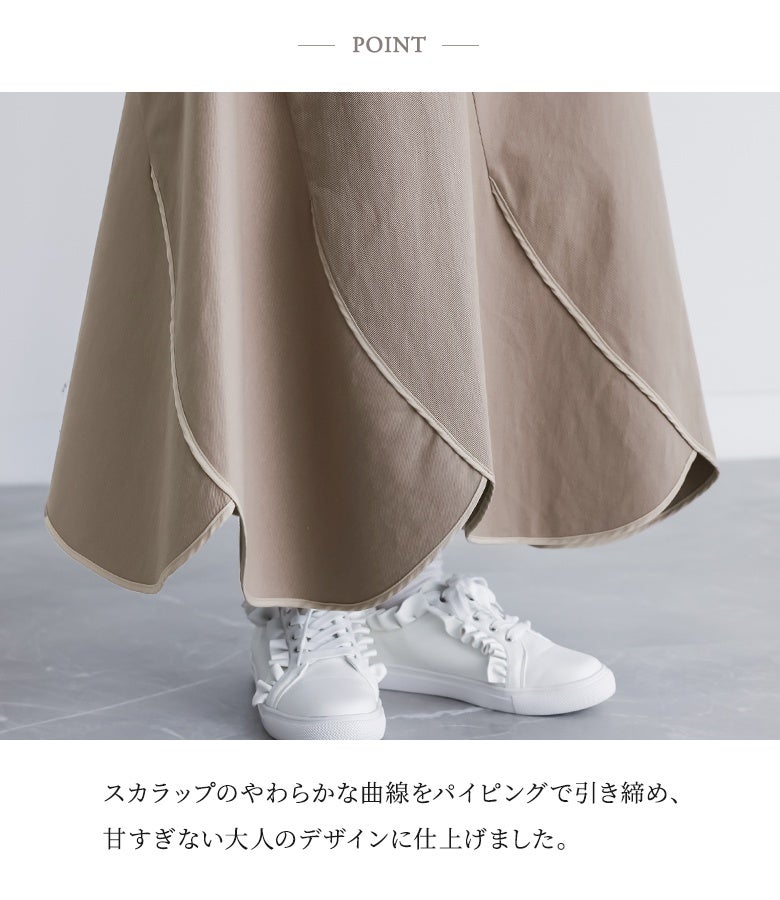 スカラップのやわらかな曲線をパイピングで引き締め、甘すぎない大人のデザインに仕上げた裾ディテール。波打つような裾ラインが足元に個性的で可憐なニュアンスをプラスします。