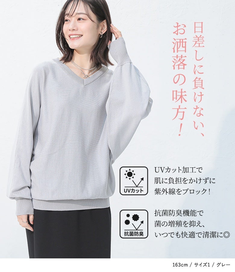 グレーのVネックドルマンニットに黒のロングスカートを合わせた、爽やかな夏のレディーススタイル。肌に負担をかけずに紫外線をブロックするUVカット加工や、菌の増殖を抑えて快適さを保つ抗菌防臭機能など、お洒落と快適さを両立した高機能な夏服。