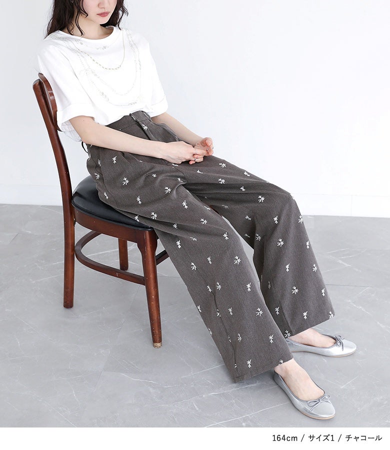 チャコールの刺繍ストレートワイドパンツに白Tシャツを合わせたキレイめモードスタイル。ハイウエスト位置のタックと繊細な刺繍が、座り姿から立ち姿まで上品な佇まいに仕立てます。