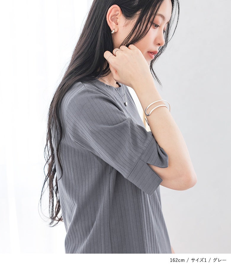 グレーのシンプルリブカットソー。袖口にさりげなくスリットが入った、他にはないひとクセデザインがお洒落な半袖Tシャツ。シルバーのバングルやリングを合わせた、抜け感のある大人の春夏コーデ。