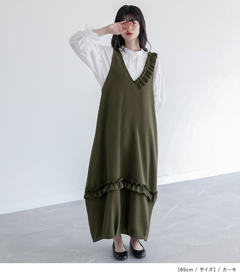 カーキのアシメフリルジャンパースカート。裾部分に横ラインで施されたフリル切り替えが優美な立体フォルムを生み出し、1枚重ねるだけでこなれ感のあるスタイルを完成させます。