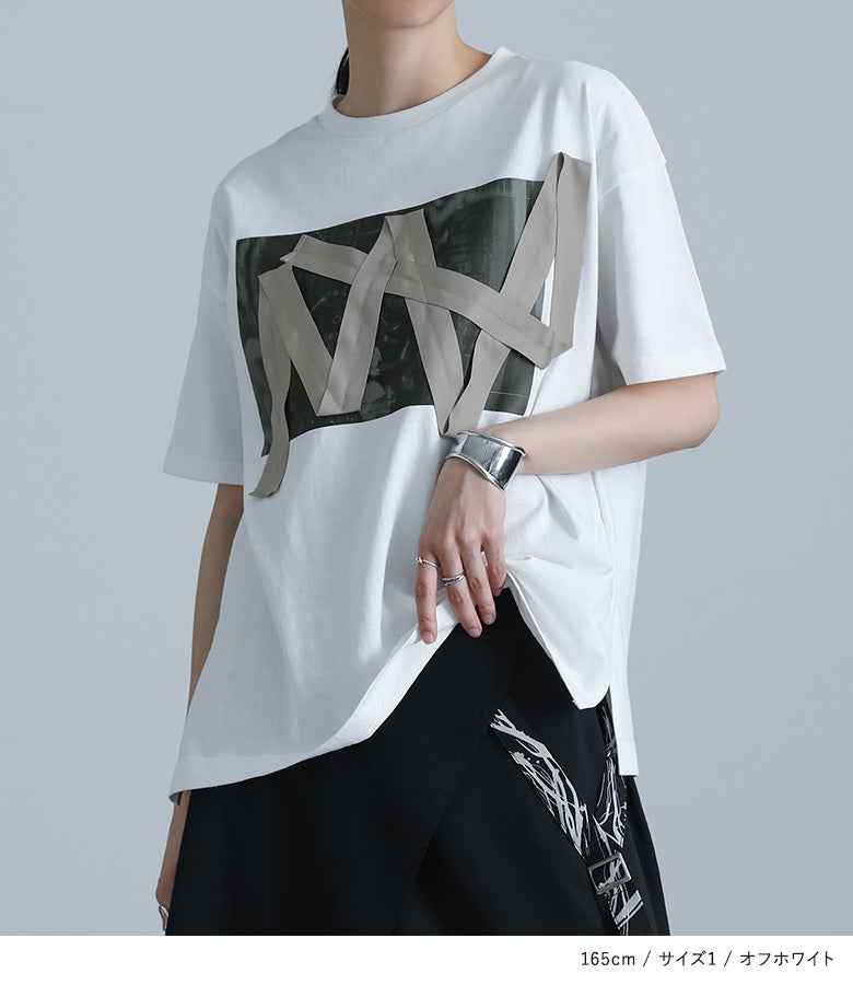 立体的なテープワークとフォト転写が目を惹くオフホワイトの半袖Tシャツ。表情豊かなデザインがコーディネートの主役となり、デイリーのカジュアルスタイルをモードに彩るおすすめのトップスです。